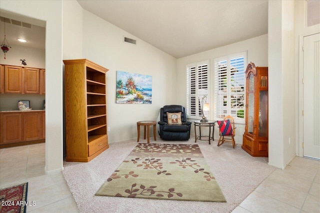 sitting room featuring light colored carpet and vaulted ceiling