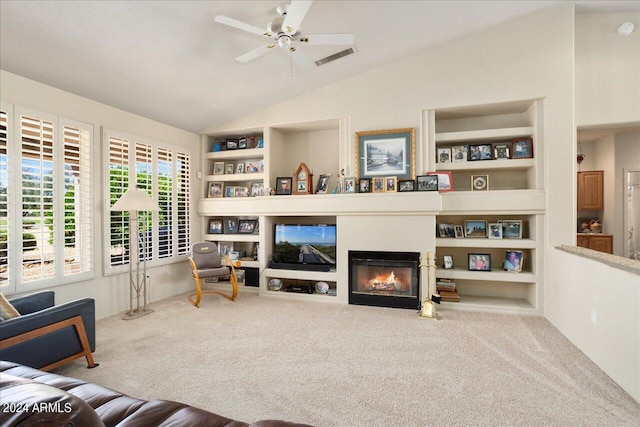 living room featuring built in features, vaulted ceiling, ceiling fan, and carpet flooring