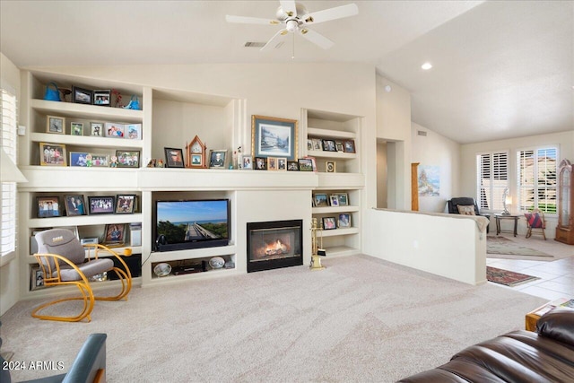 living room with lofted ceiling, ceiling fan, carpet, and built in shelves