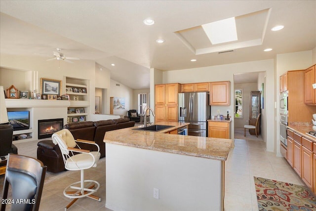 kitchen featuring light stone counters, ceiling fan, sink, light tile flooring, and stainless steel fridge with ice dispenser