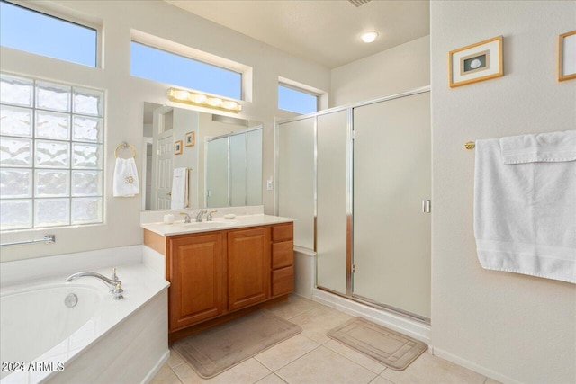 bathroom with tile floors, shower with separate bathtub, and vanity