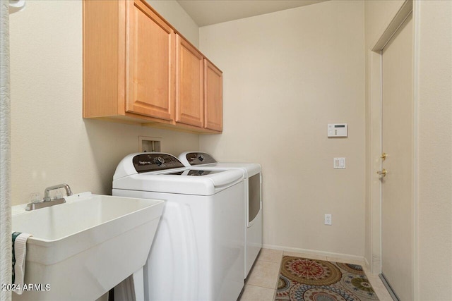 washroom with washer and clothes dryer, washer hookup, sink, light tile floors, and cabinets