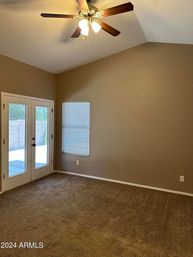 carpeted spare room with lofted ceiling, ceiling fan, and french doors