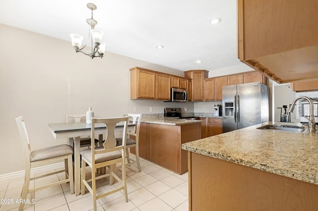 kitchen featuring appliances with stainless steel finishes, sink, decorative light fixtures, light stone countertops, and light tile patterned flooring