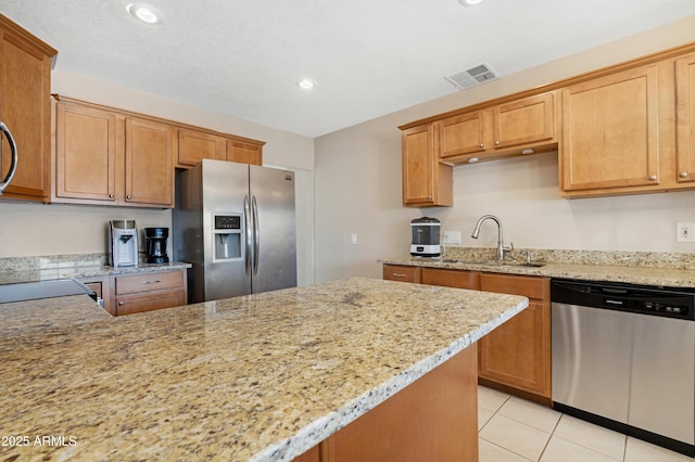 kitchen featuring sink, light stone counters, and appliances with stainless steel finishes