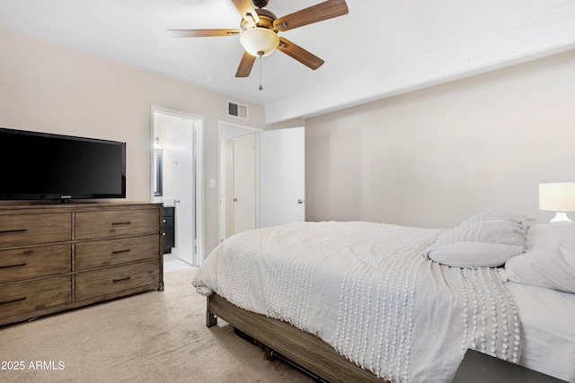 bedroom featuring ceiling fan, connected bathroom, and light carpet