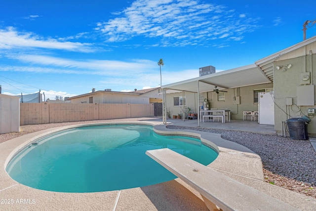 view of swimming pool featuring a diving board, a patio, ceiling fan, and central AC