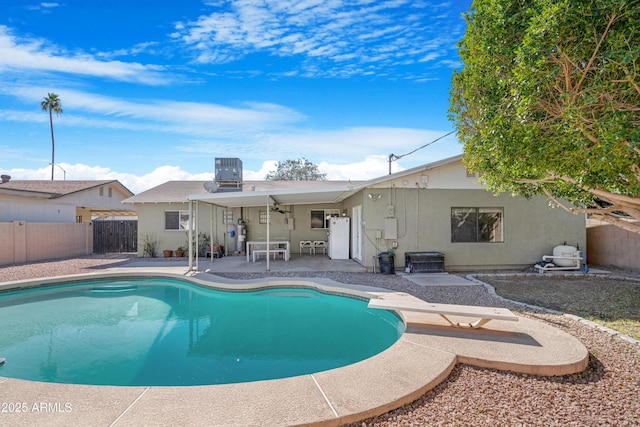 view of pool with a diving board, a patio area, and cooling unit