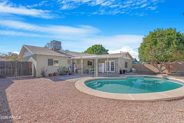 view of swimming pool with french doors, central AC unit, and a patio area