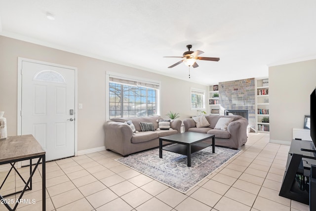 tiled living room featuring a fireplace, built in features, ceiling fan, and ornamental molding