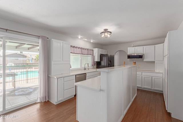 kitchen with wood-type flooring, sink, a kitchen island, stainless steel appliances, and white cabinets