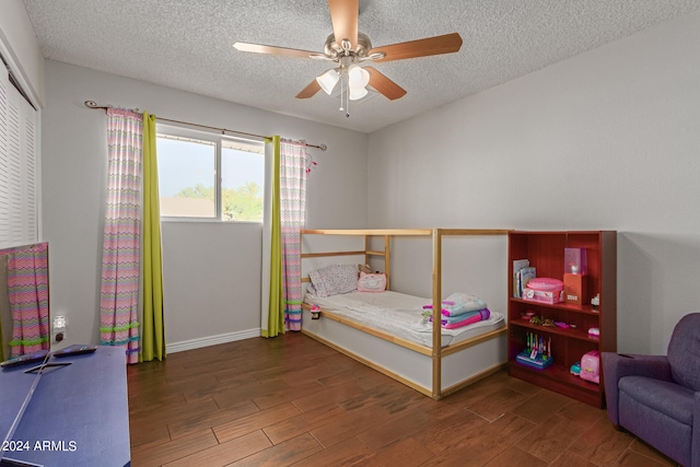 bedroom with a textured ceiling, dark hardwood / wood-style floors, and ceiling fan