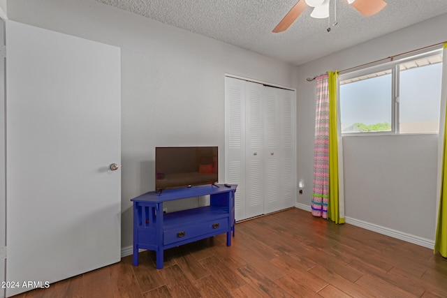 interior space with a textured ceiling, dark wood-type flooring, and ceiling fan