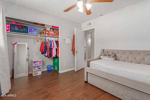 bedroom with a closet, ceiling fan, a textured ceiling, and dark hardwood / wood-style flooring