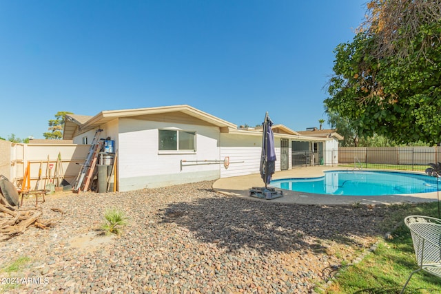 back of house featuring a fenced in pool