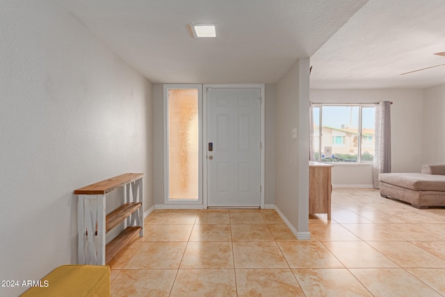 tiled entrance foyer featuring ceiling fan