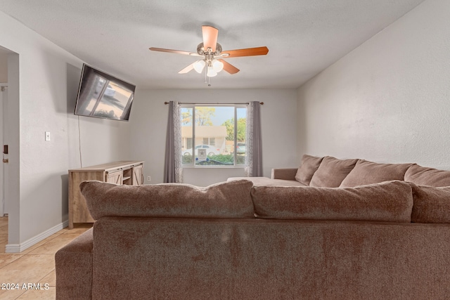 living room with ceiling fan, a textured ceiling, and light tile patterned floors