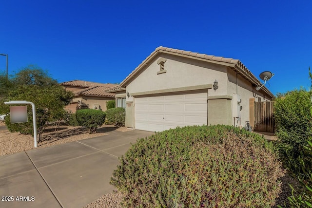 40713 N Courage Trl, Anthem, AZ 85086 - view of front of home featuring stucco siding, an attached garage, a tiled roof, and concrete driveway