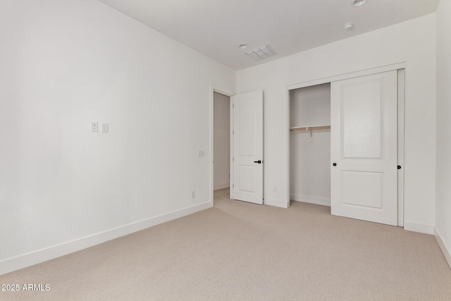 unfurnished bedroom featuring light carpet, baseboards, and a closet