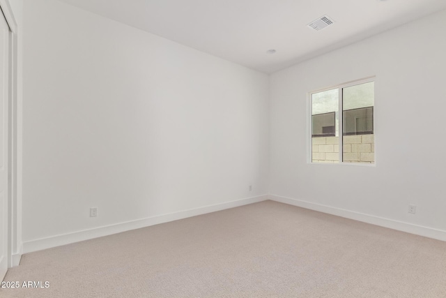 spare room with light carpet and baseboards
