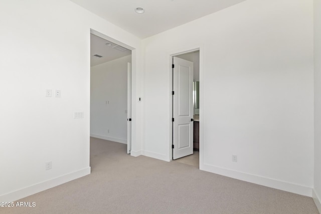 spare room with light carpet and baseboards