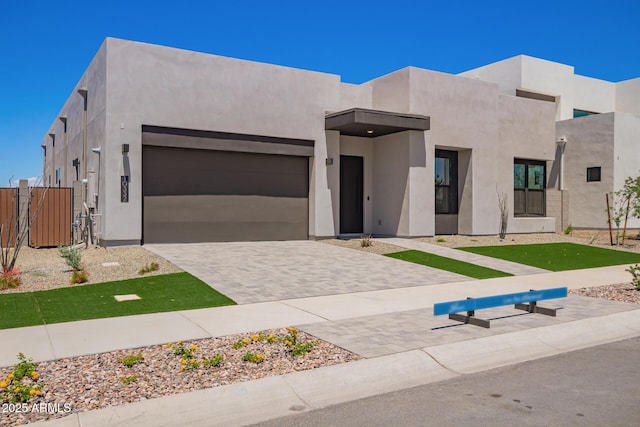 view of front of property featuring a garage, stucco siding, and fence