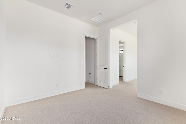 empty room featuring light carpet and baseboards