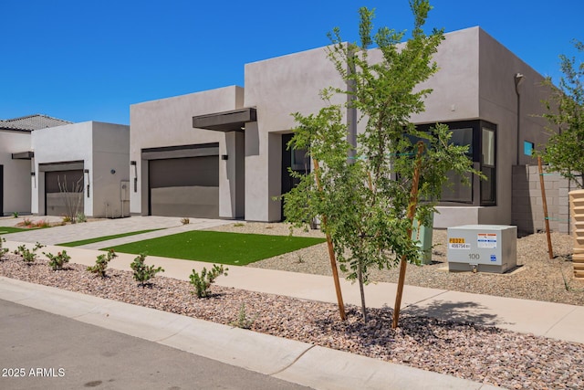 view of front of property featuring an attached garage, driveway, and stucco siding
