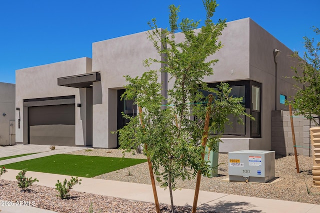 view of front of home featuring an attached garage, stucco siding, and driveway