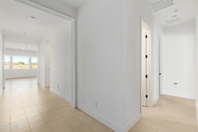 hall with light tile patterned floors, baseboards, and recessed lighting