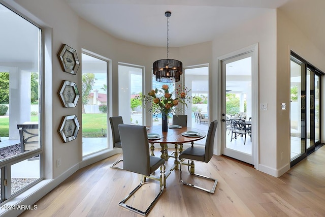 dining area with a healthy amount of sunlight, light hardwood / wood-style floors, and a notable chandelier