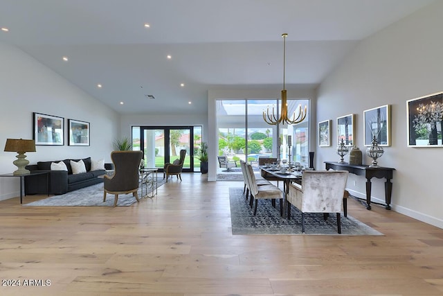 dining room featuring a chandelier, light hardwood / wood-style floors, and vaulted ceiling