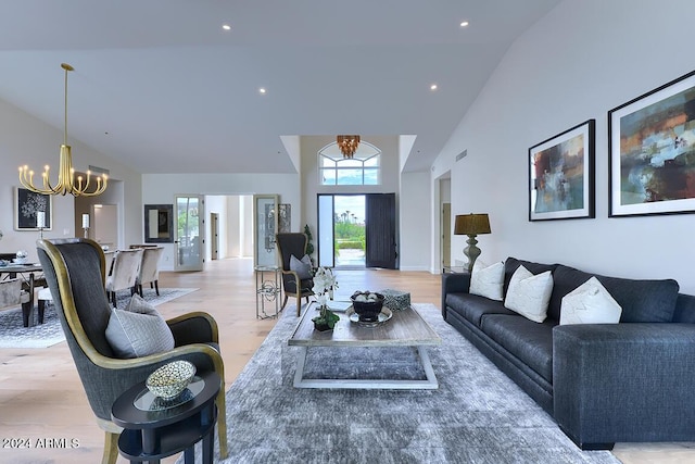 living room with a healthy amount of sunlight, light hardwood / wood-style floors, and an inviting chandelier