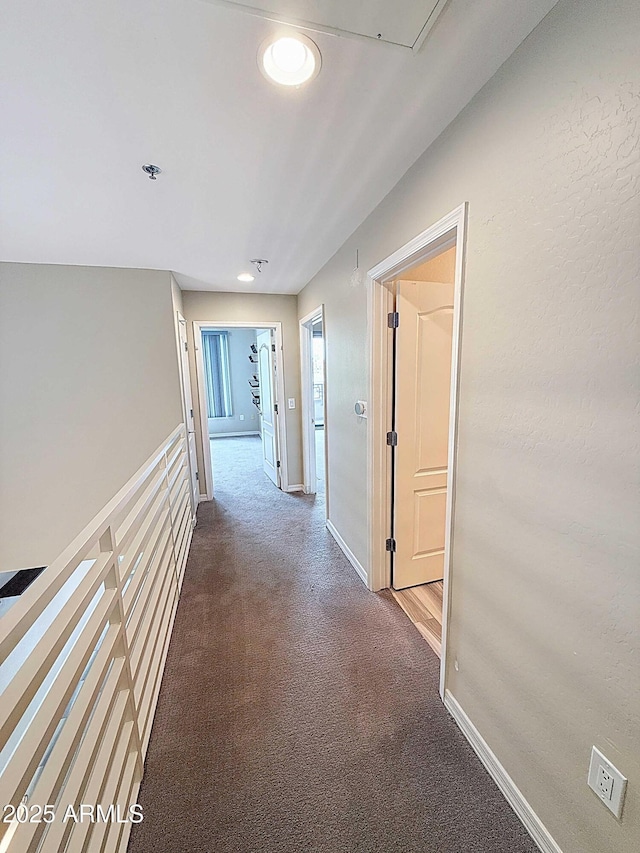 hallway with carpet flooring and baseboards