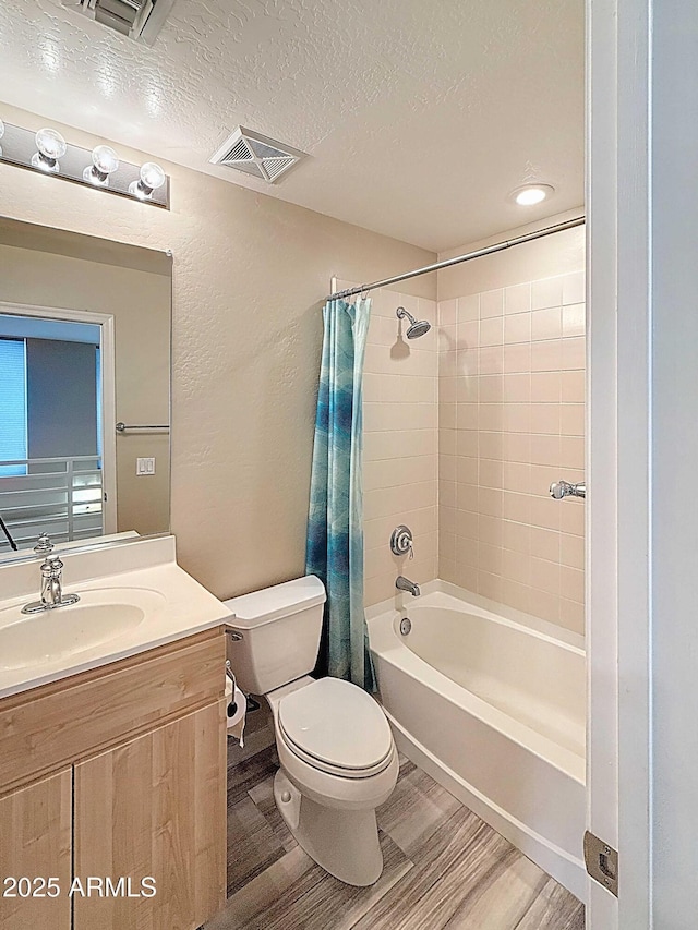 full bathroom with a textured ceiling, vanity, visible vents, toilet, and shower / tub combo with curtain