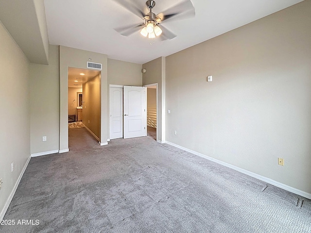 unfurnished bedroom featuring ensuite bathroom, a closet, visible vents, carpet floors, and baseboards