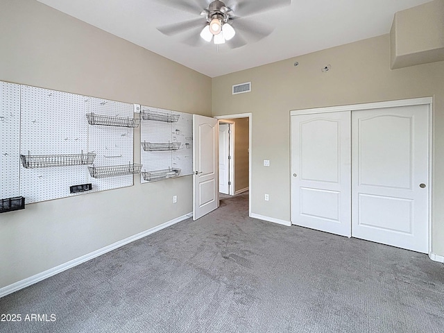 unfurnished bedroom with carpet, a closet, visible vents, vaulted ceiling, and baseboards