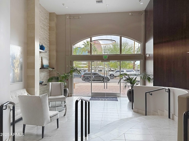 interior space featuring a high ceiling and light tile patterned flooring
