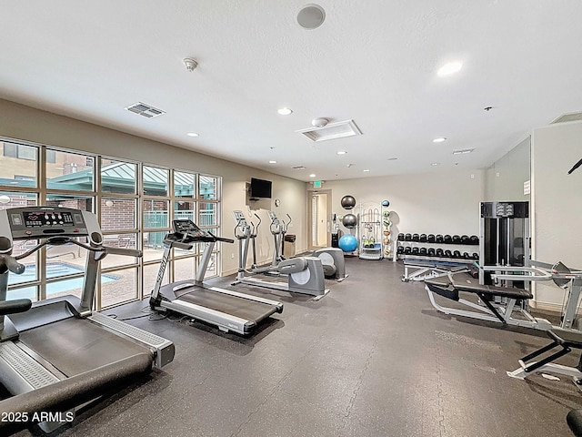 workout area with a textured ceiling, visible vents, and recessed lighting