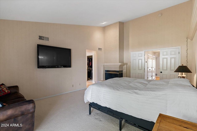 bedroom with a high ceiling, carpet, a spacious closet, and a closet