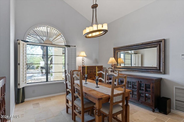 dining area featuring high vaulted ceiling and a chandelier