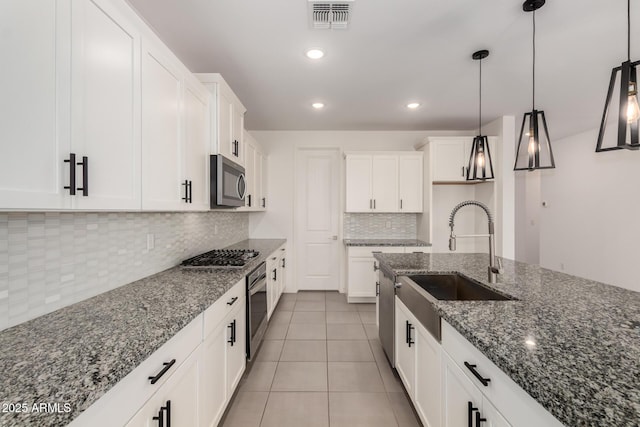22568 E Rosa Rd, Queen Creek, AZ 85142 - kitchen featuring a sink, stainless steel appliances, decorative backsplash, light tile patterned floors, and decorative light fixtures