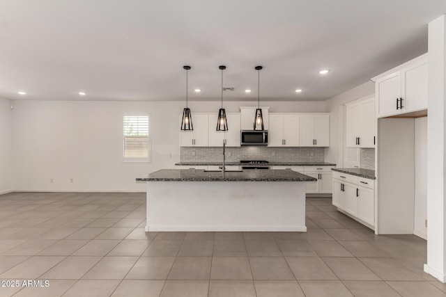22568 E Rosa Rd, Queen Creek, AZ 85142 - kitchen with stainless steel microwave, decorative backsplash, dark stone countertops, a center island with sink, and recessed lighting