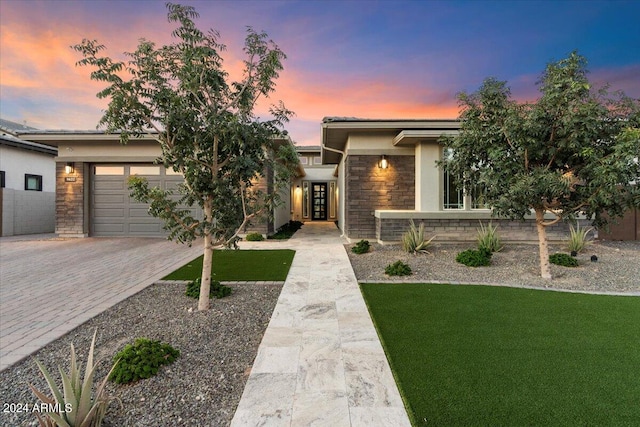 prairie-style house with a garage and a lawn