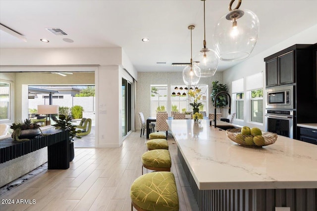 kitchen featuring a healthy amount of sunlight, appliances with stainless steel finishes, and a kitchen island with sink