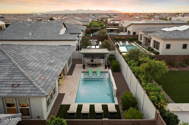 pool at dusk featuring a patio