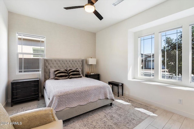 bedroom featuring light hardwood / wood-style flooring, multiple windows, and ceiling fan