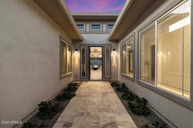 exterior entry at dusk featuring a patio