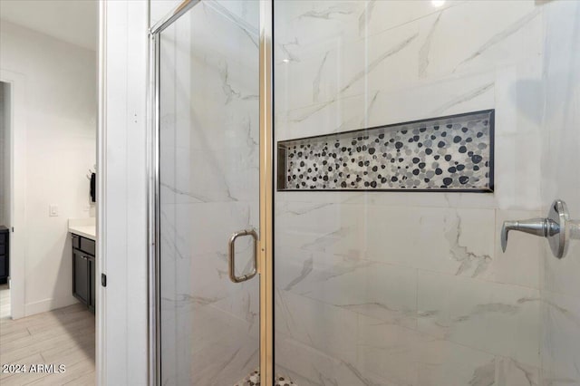 bathroom with vanity, walk in shower, and wood-type flooring