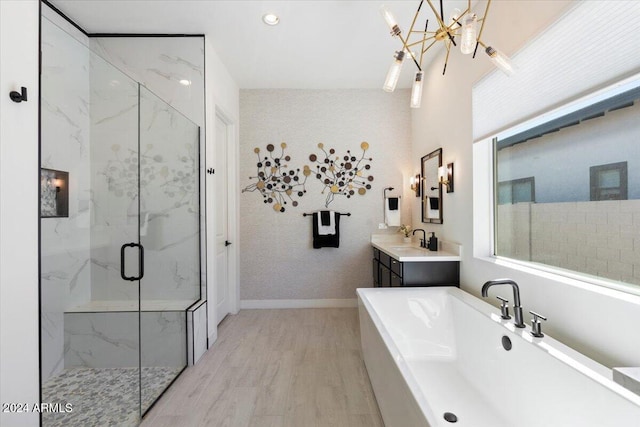 bathroom featuring vanity, shower with separate bathtub, hardwood / wood-style flooring, and an inviting chandelier